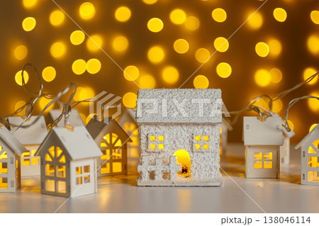 Christmas wooden houses garlands with lights in the snow on glowing lights bokeh background 138046114