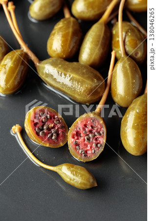 Canned capers on a black plate. 138046265