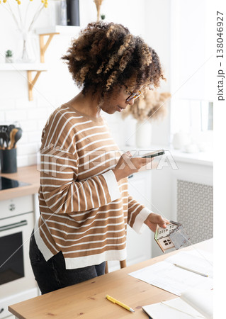 female architect or realtor holds mock up of house in her hands and photographs it for client.  138046927