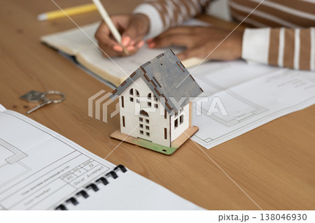close up view of house layout that stands on table. female architect is working on creating. 138046930