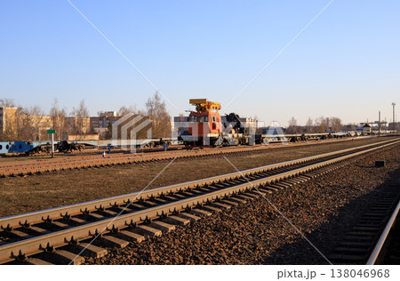 Track-laying crane in the background of a railroad track. Specialized piece of railway equipment Track-laying crane in the background of a railroad track. Specialized piece of railway equipment 138046968