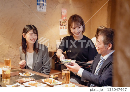 居酒屋で料理を提供する女性スタッフ 居酒屋で料理を提供する女性スタッフ 138047467