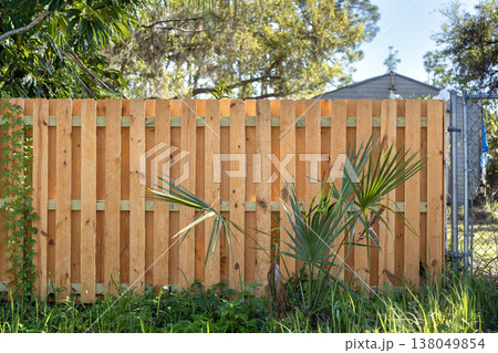Wooden picket fence on green lawn surrounding property grounds for backyard protection and privacy 138049854