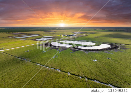 Water reservoirs for cows grazing on green farm pasture. Drinking ponds at free range farm. Feeding of cattle on farmland grassland Water reservoirs for cows grazing on green farm pasture. Drinking ponds at free range farm. Feeding of cattle on farmland grassland 138049882