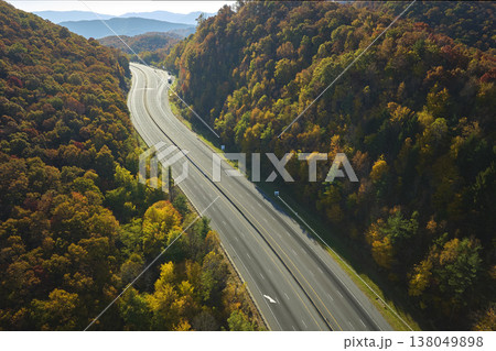 View from above of empty deserted I-40 freeway route in North Carolina leading to Asheville thru Appalachian mountains with yellow fall woods. Interstate transportation concept View from above of empty deserted I-40 freeway route in North Carolina leading to Asheville thru Appalachian mountains with yellow fall woods. Interstate transportation concept 138049898