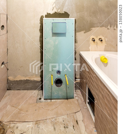 Unfinished reconstruction of bathroom or toilet with ceramic tiles installed on walls of drywall, place for lavatory and bath. 138050023