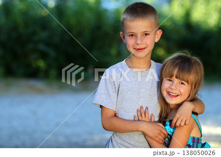 Two little children brother and sister together. Girl in dress hugging boy. Family relations concept. Two little children brother and sister together. Girl in dress hugging boy. Family relations concept. 138050026
