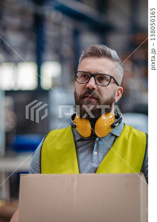 Warehouse or factory worker carrying products in box. 138050165