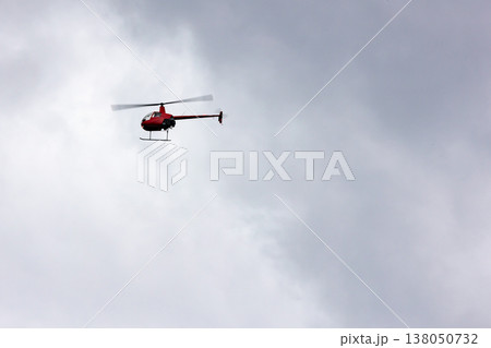 曇天を旋回する赤いヘリコプター 138050732