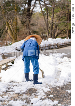 雪の兼六園で雪かきをする人 雪の兼六園で雪かきをする人 138050811