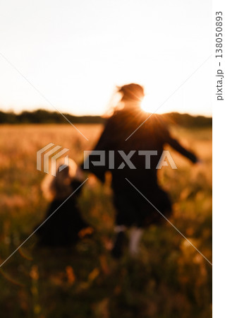 Family Joyful Moment. Caucasian Mother And Girl Sharing Joyful Sunset Stroll In Open Meadow 138050893