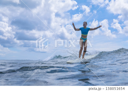 Female Surfer Basking In Summer Sunshine Amid Crashing Surf And Cheerful Mood Female Surfer Basking In Summer Sunshine Amid Crashing Surf And Cheerful Mood 138051654