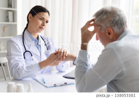 Female doctor holding patient hands during emotional consultation in clinic Female doctor holding patient hands during emotional consultation in clinic 138053381