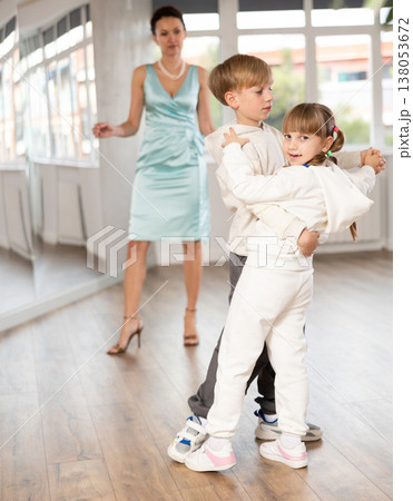 Preteen boy and girl refining slow foxtrot technique in dance hall Preteen boy and girl refining slow foxtrot technique in dance hall 138053672