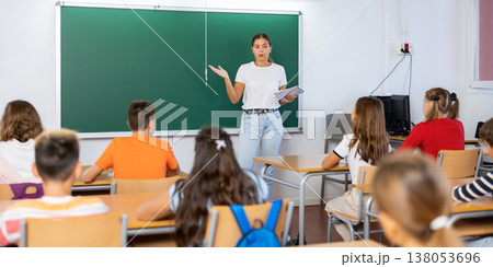Woman teacher explaining new theme to children during class in primary school 138053696
