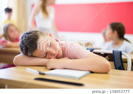Tired school boy sleeping in classroom during lesson 138053777