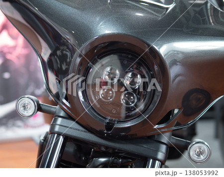 Modern Motorcycle LED Headlight Glows Within Aerodynamic Fairing, Circular Beam And Daytime Running Lights, Sleek Glossy Finish, Urban Showroom Mood And Premium Touring Presence Emphasizing Modern Motorcycle LED Headlight Glows Within Aerodynamic Fairing, Circular Beam And Daytime Running Lights, Sleek Glossy Finish, Urban Showroom Mood And Premium Touring Presence Emphasizing 138053992