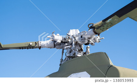 Closeup Helicopter Rotor Hub Exposed Components Against Clear Blue Sky Showing Weathered Paint, Grease And Bolts, Detailed Swashplate And Pitch Control Linkage, Visible Gearbox Elements 138053993