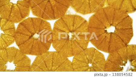Orange slices placed closely together showing their textures and colors in a bright setting Orange slices placed closely together showing their textures and colors in a bright setting 138054582