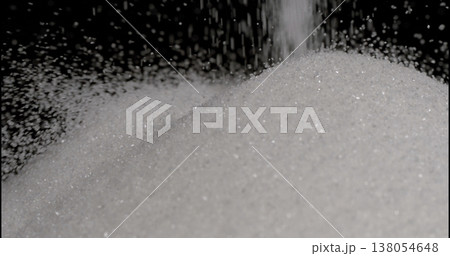 Sugar falls onto a large pile in a dark setting during a food preparation scene Sugar falls onto a large pile in a dark setting during a food preparation scene 138054648