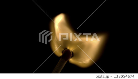 Flame burning on a matchstick held in a dark setting with smoke rising in the air Flame burning on a matchstick held in a dark setting with smoke rising in the air 138054674