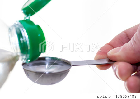 液体の調味料を計量スプーンで量る 138055488