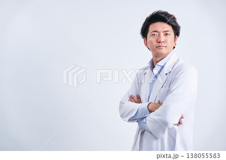 白背景で腕組みをする白衣姿の30代の男性の医師の自信に満ちた爽やかな表情 138055583