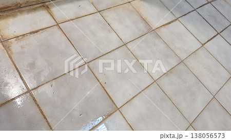 Realistic dirty old beige floor tiles texture with stained black grout lines Realistic dirty old beige floor tiles texture with stained black grout lines 138056573