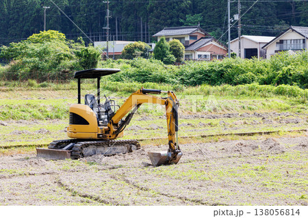 畑を耕す小型油圧ショベル 138056814