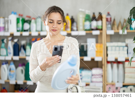 Young woman scanning QR-code on detergent in supermarket Young woman scanning QR-code on detergent in supermarket 138057461