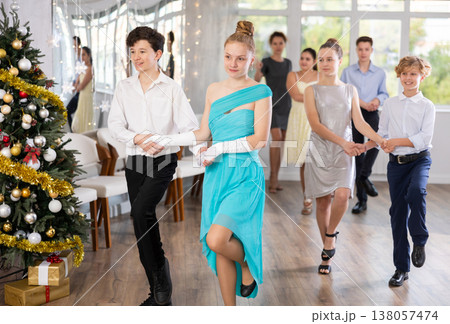 Celebrating Christmas in dance class - girls and boys dance the Moresco dance near New Year tree 138057474