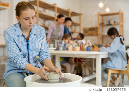 Girl working at a potter's wheel 138057476