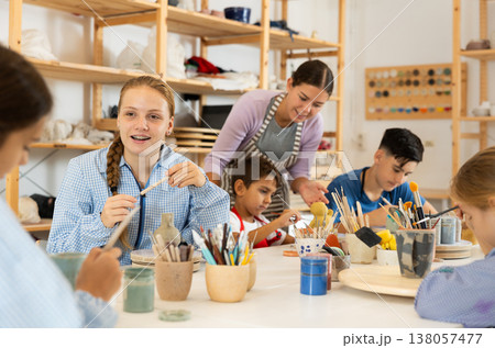 Teenage girl speaking to a circle member while processing ceramic items 138057477