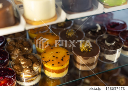 Closeup of various delicious sweet cakes and pastries displayed in bakery display case 138057478