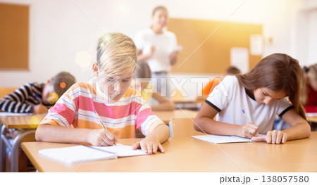 Girl and boy exercising in classroom Girl and boy exercising in classroom 138057580