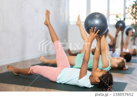 African girl participates in group lesson with softball, modern sport in studio. 138057652
