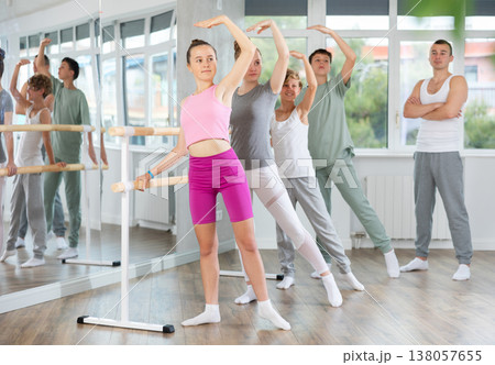 Teenage boys and girls practicing battement tendu position of ballet in dancehall 138057655