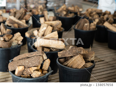 Firewood stacked in plastic buckets in store warehouse 138057658