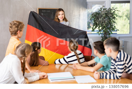 Teacher showing Germany flag to group of schoolchildren Teacher showing Germany flag to group of schoolchildren 138057696