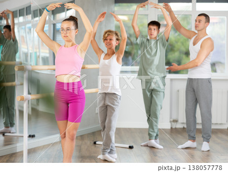 Teenage boys and girls practicing fifth position of ballet in dancehall 138057778