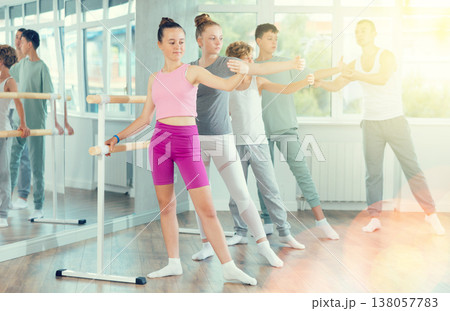 Teenage boys and girls practicing battement tendu position of ballet in dancehall 138057783