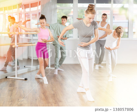 Girls and boys are learning various dance and ballet movements in studio 138057806