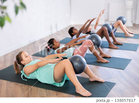Portrait of childrens with pilates balls, pumping press during group class in fitness studio Portrait of childrens with pilates balls, pumping press during group class in fitness studio 138057817