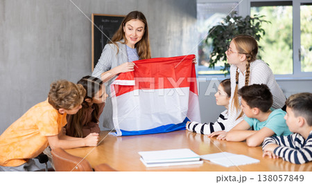 Teacher showing Holland flag to group of schoolchildren 138057849