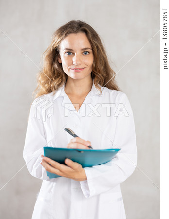 Young female doctor taking notes in studio 138057851