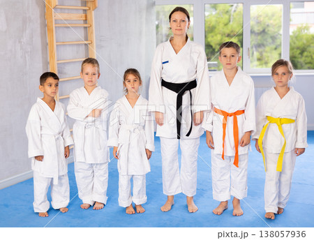 Portrait of female karate or judo coach with her students little children in gym 138057936