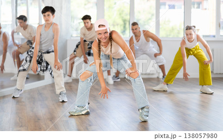 Girl in baseball cap with two hair pigtails with group of teenage friends, learn to dance hip hop 138057980