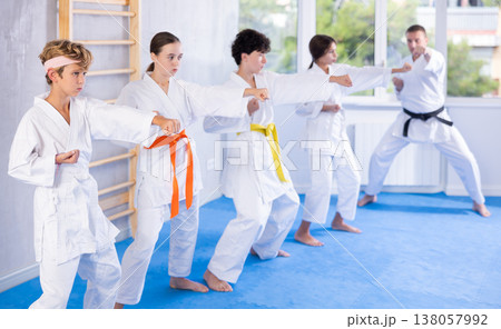 Children students repeat position and perform sequence of punches and painful techniques kata Children students repeat position and perform sequence of punches and painful techniques kata 138057992