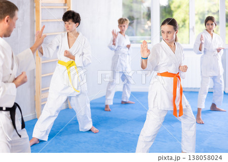 Children students repeat position and perform sequence of punches and painful techniques kata Children students repeat position and perform sequence of punches and painful techniques kata 138058024