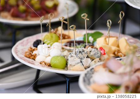 Assorted catering cheese platter with blue cheese mozzarella walnut and grape on buffet table for event or party decoration with delicious snacks Assorted catering cheese platter with blue cheese mozzarella walnut and grape on buffet table for event or party decoration with delicious snacks 138058225